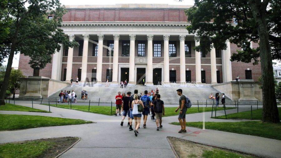 FILE - In this Aug. 13, 2019 file photo, students walk near the Widener Library in Harvard Yard at Harvard University in Cambridge, Mass. The Ivy League school announced Monday, July 6, 2020, that as the coronavirus pandemic continues its freshman class will be invited to live on campus this fall, while most other undergraduates will be required learn remotely from home. (AP Photo/Charles Krupa, File)
