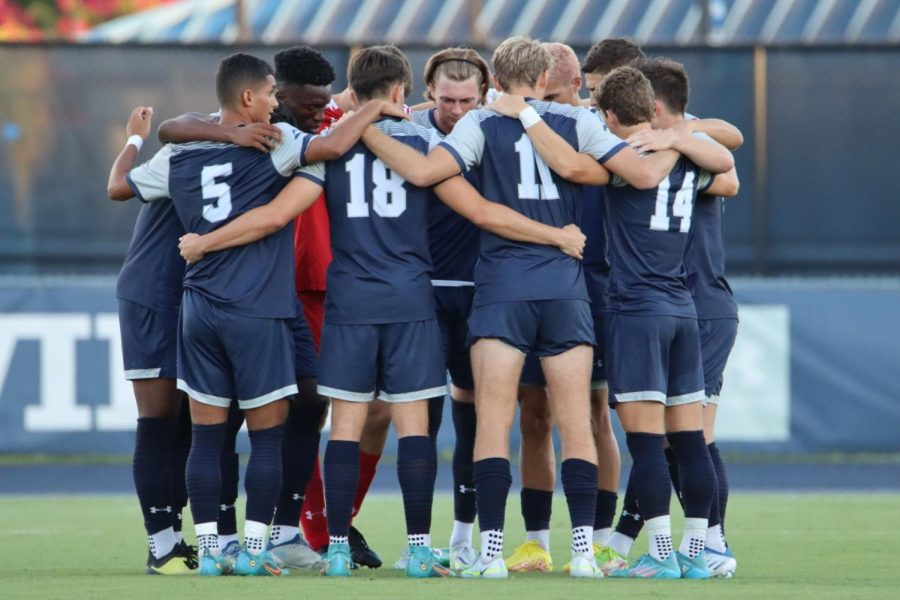 UNF soccer team huddles around each other.