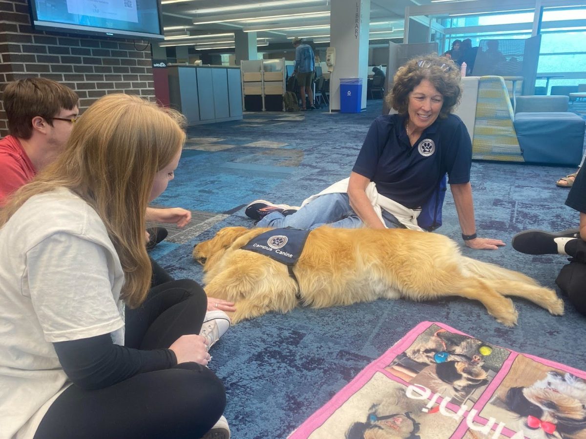Hannah Kalas and other students gather around Tucker. (Madelyn Schneider)