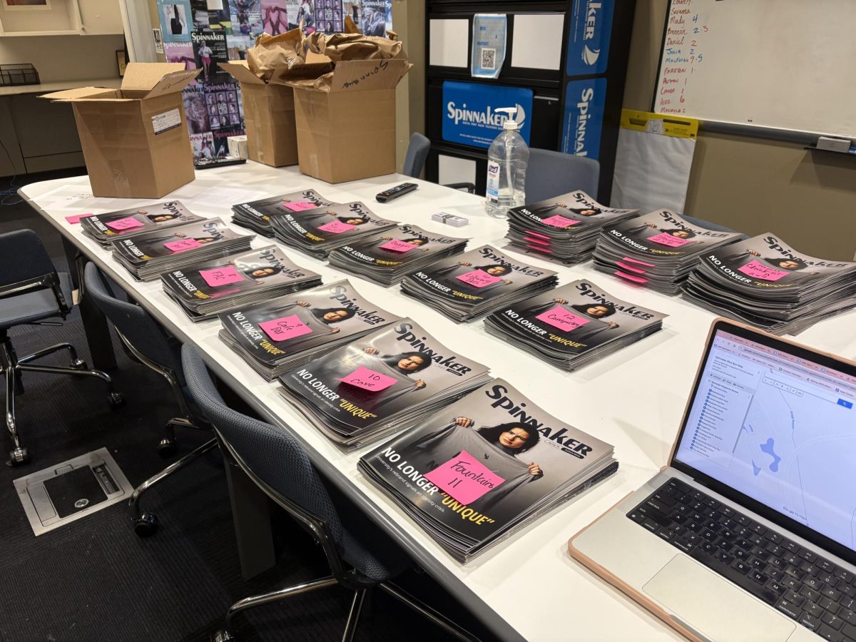 Stacks of Spring 2025 Spinnaker magazines lined up on the newsroom table before distribution.